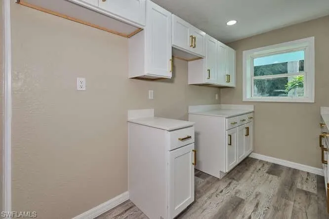 Kitchen with white cabinets and light hardwood / wood-style floors