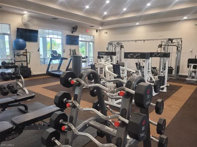 Workout area featuring crown molding, recessed lighting, and a raised ceiling