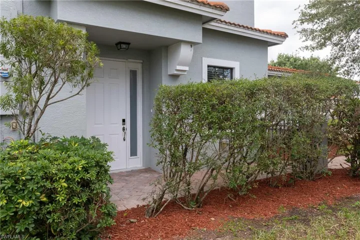 View of exterior entry featuring stucco siding and a tiled roof