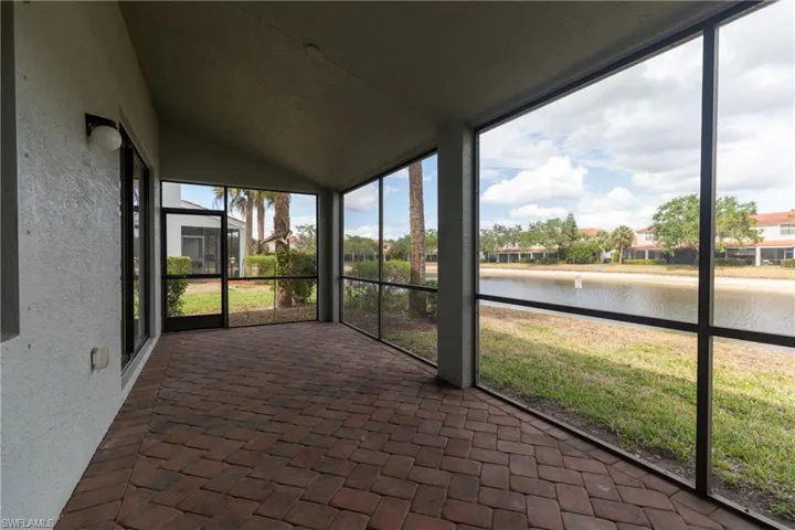Unfurnished sunroom featuring a water view, healthy amount of natural light, and vaulted ceiling