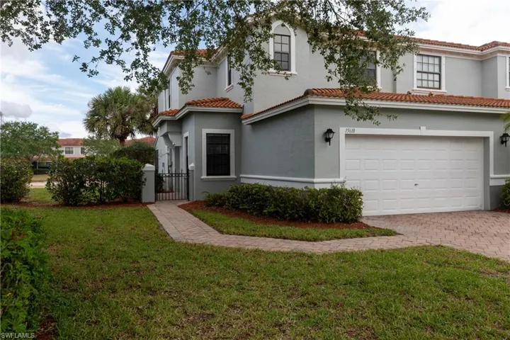 Mediterranean / spanish home with an attached garage, a gate, decorative driveway, and stucco siding