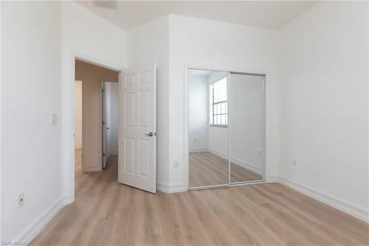 Bedroom with light wood-style finished floors and a closet