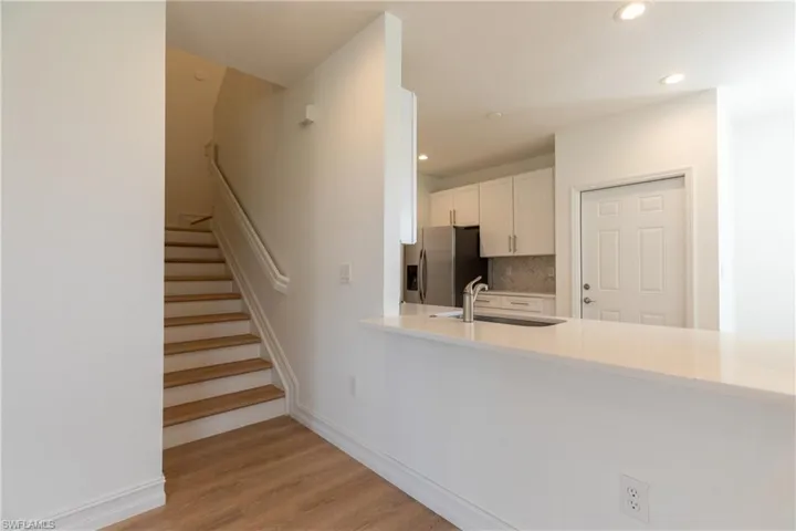 Stairs featuring recessed lighting and light wood-style finished floors