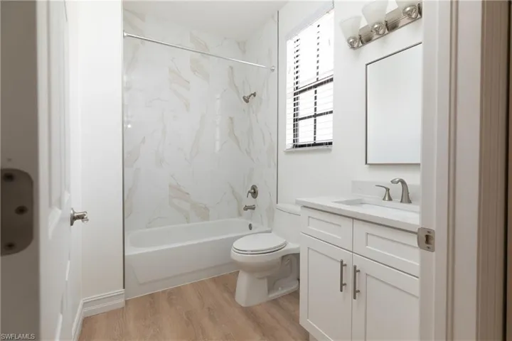 Upstairs guest bathroom featuring vanity, light-style wood finished floors, and shower/tub combination