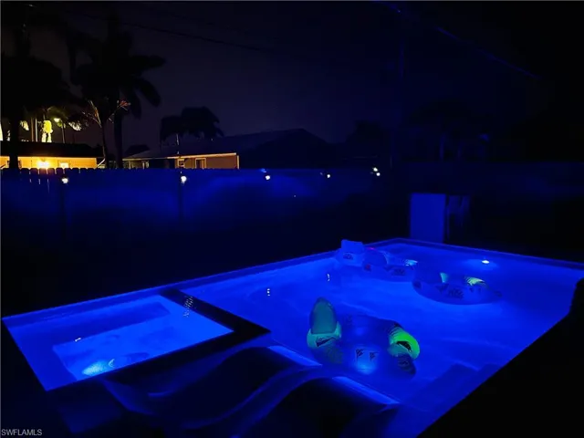 Pool at twilight with an in-ground hot tub