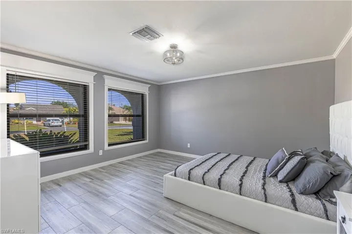 Unfurnished bedroom featuring crown molding and light wood-style flooring