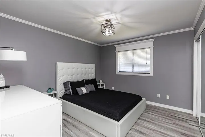 Bedroom with light wood-style floors and crown molding