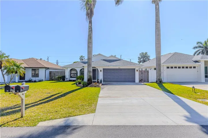 Single story home featuring concrete driveway and an attached garage