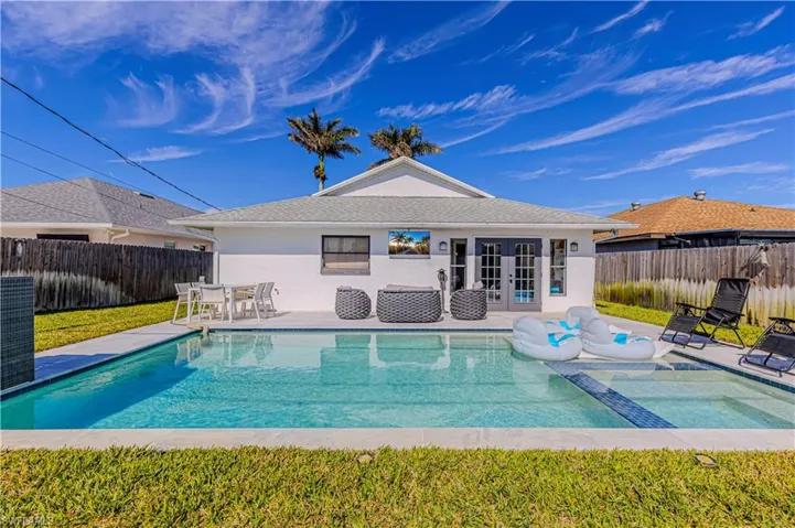 View of pool featuring french doors, a fenced backyard, a patio area, and a pool with connected hot tub