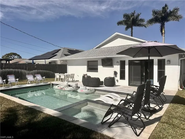 View of swimming pool featuring a patio, a pool with connected hot tub, and outdoor dining space