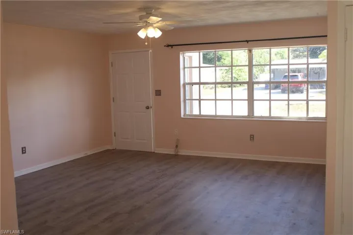 Empty room with dark wood finished floors and ceiling fan