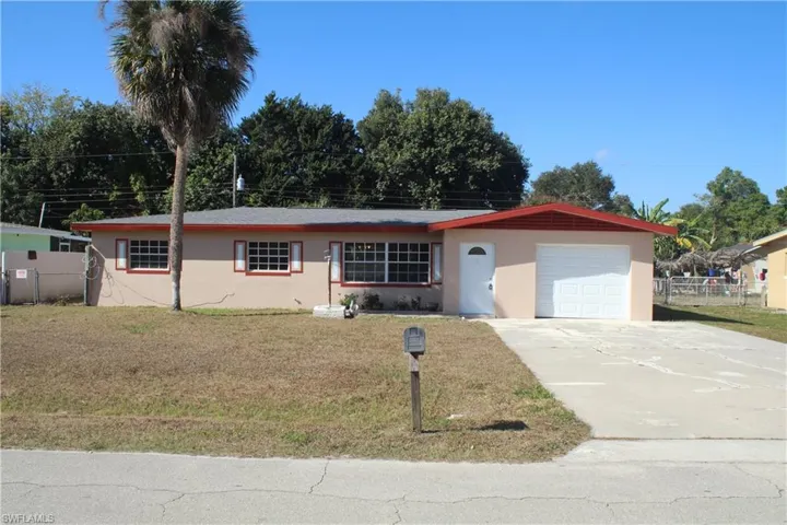 Single story home featuring driveway, stucco siding, and an attached garage