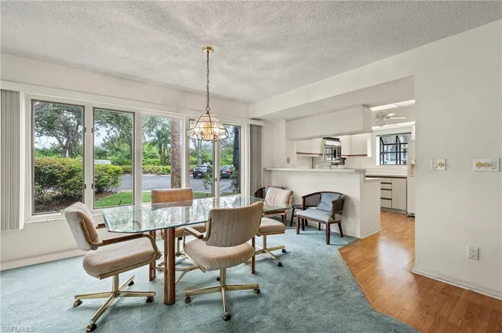 Dining space featuring a textured ceiling, a chandelier, and light hardwood / wood-style floors