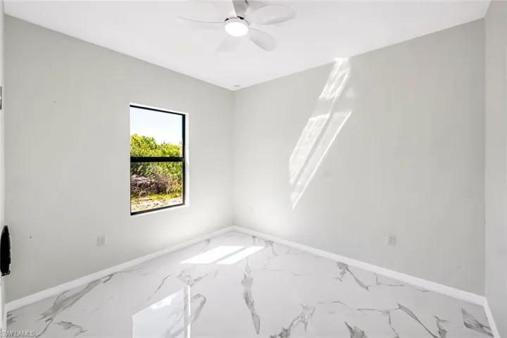 Unfurnished room with a ceiling fan and marble look tiles