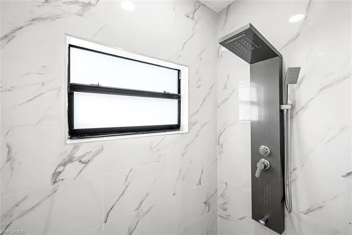 Bathroom with a marble finish shower