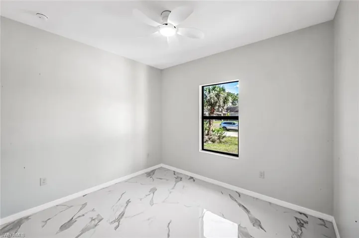 Spare room with ceiling fan and light marble finish flooring