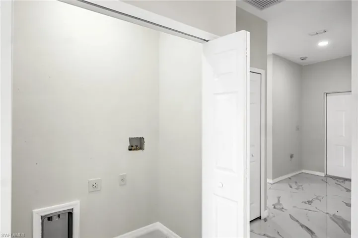 Laundry area with light marble finish floors, hookup for a washing machine, hookup for an electric dryer, and recessed lighting