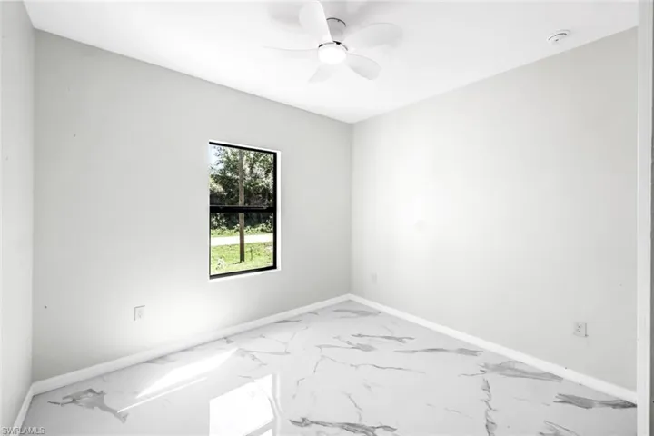 Empty room with ceiling fan and light marble finish flooring