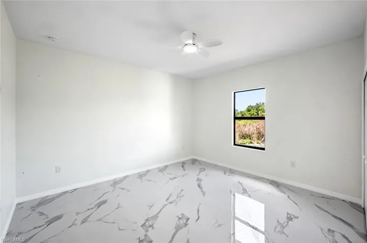 Empty room featuring baseboards and ceiling fan