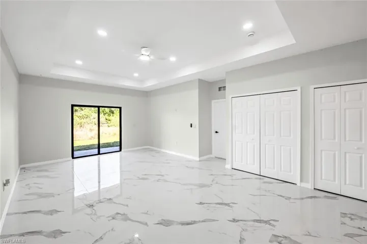 Unfurnished bedroom featuring two closets, recessed lighting, access to exterior, light marble finish flooring, and ceiling fan