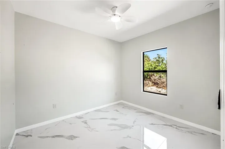 Empty room with light marble finish flooring and ceiling fan