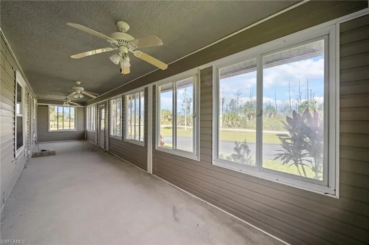 Unfurnished sunroom featuring a ceiling fan