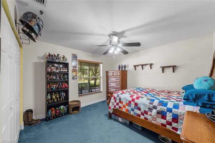 Carpeted bedroom with a ceiling fan and baseboards