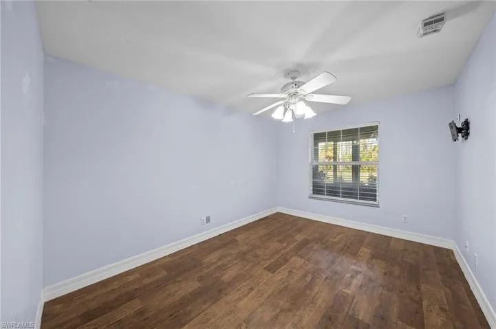Empty room featuring dark wood finished floors and ceiling fan