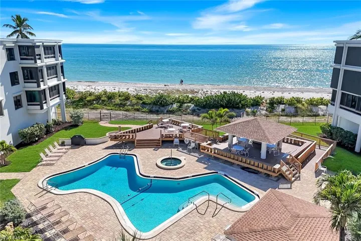Community pool featuring a beach view, a community hot tub, a patio area, and a gazebo