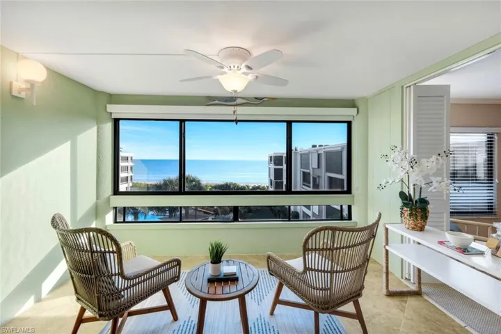 Living area featuring a water view, ceiling fan, and tile patterned flooring