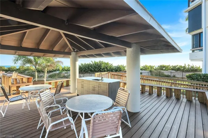 Wooden terrace with outdoor dining area and a sink