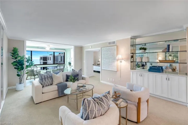 Living area featuring crown molding, light carpet, and expansive windows