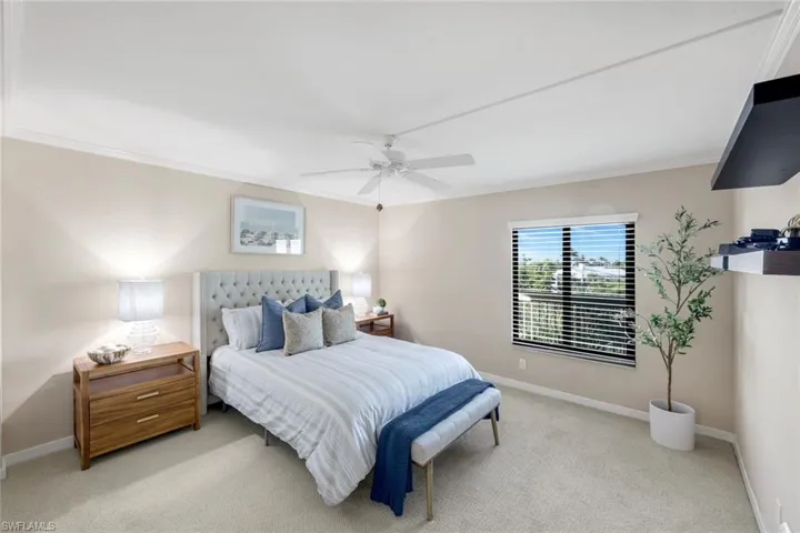 Bedroom featuring carpet flooring, ceiling fan, and ornamental molding