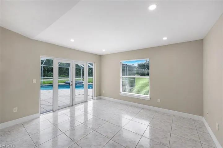 Recessed lighting illuminates the tiled flooring and neutral wall tones