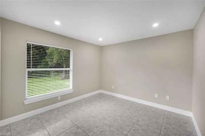 Recessed ceiling lighting, a window with horizontal blinds, tiled flooring, and light-toned wall finishes