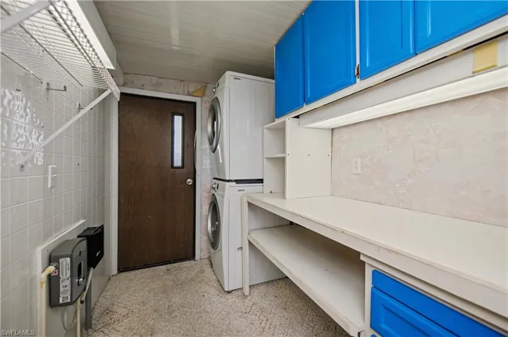 Washroom featuring stacked washer and clothes dryer