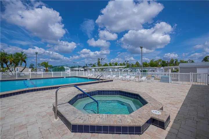 Community pool with a patio area and a hot tub
