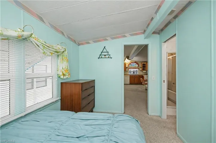 Bedroom featuring light carpet and baseboards