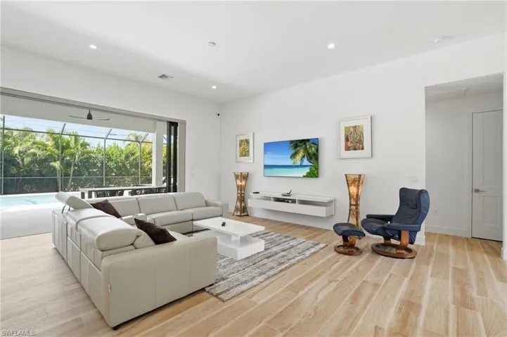 Living area featuring a sunroom, light wood finished floors, and recessed lighting