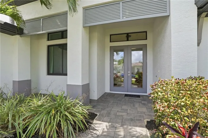View of exterior entry with stucco siding and french doors