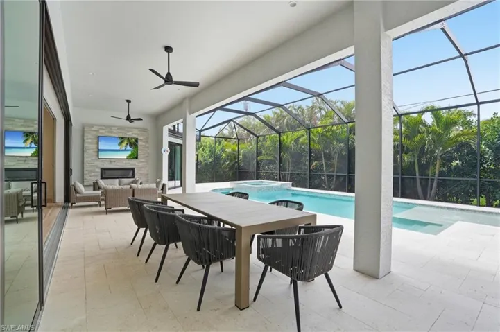 Relaxing pool / spa featuring a patio area, a sunroom, a lanai, and outdoor lounge area