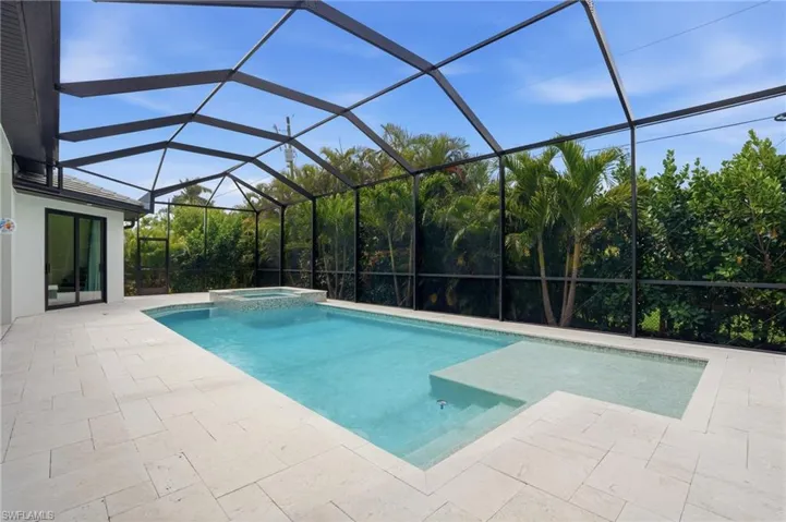 Integrated pool / spa with a sunroom, a patio, and a lanai