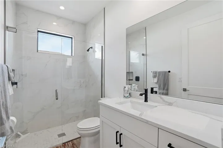 Full bathroom featuring vanity and a marble finish shower