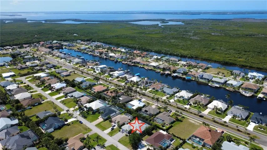 Aerial perspective of suburban area featuring a nearby body of water
