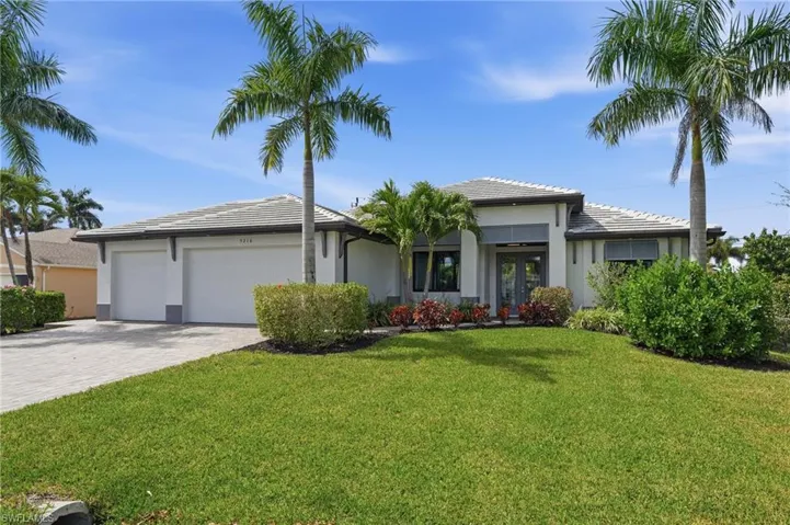 Prairie-style home with an attached garage, decorative driveway, a front yard, a tiled roof, and stucco siding