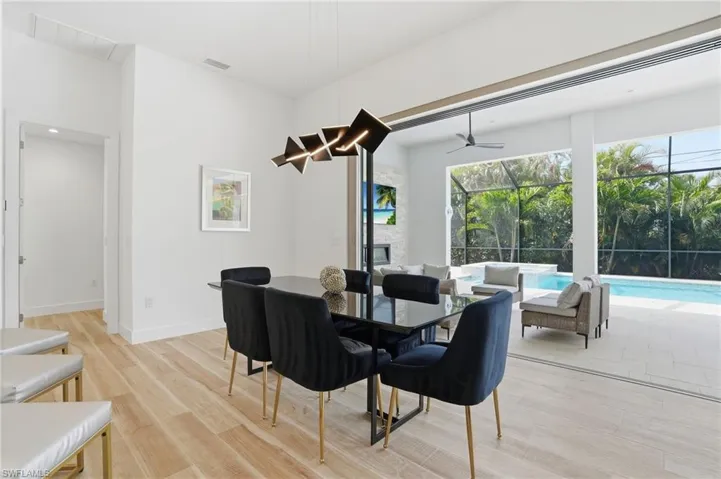 Dining space with a sunroom, light wood finished floors, and ceiling fan
