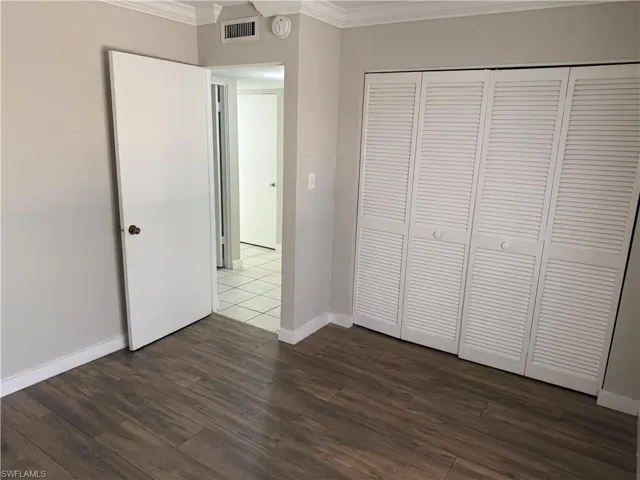Wood-finish plank flooring throughout, complemented by white baseboards and crown molding