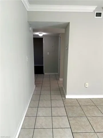 Neutral-toned square tile flooring throughout, complemented by light gray walls and white baseboards