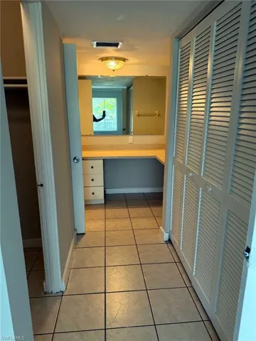 Vanity area featuring a built-in countertop with integrated single-drawer cabinetry, a wall-mounted mirror, and overhead flush-mount lighting