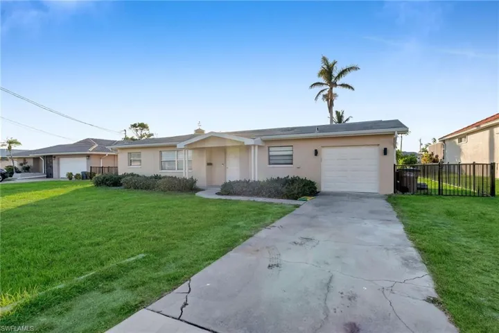 Ranch-style home with a front yard and a garage